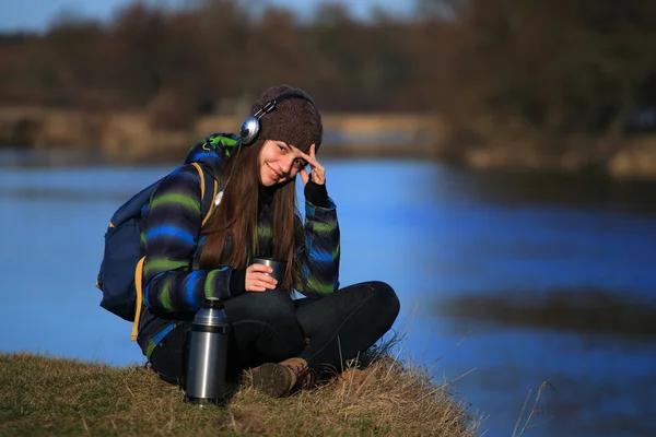 Jong meisje, zittend op de grond en luister de muziek — Stockfoto