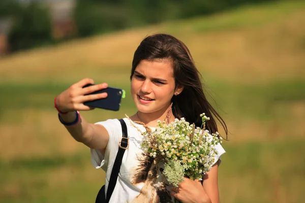 10 代の少女は、彼女の携帯電話で楽しみを得る — ストック写真