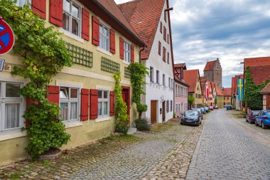 DINKELSBUEHL, BAVARIA, GERMANY - CIRCA JULY, 2021: The Obere Schmiedgasse and Rothenburger Tor of Dinkelsbuehl town, Almanya.