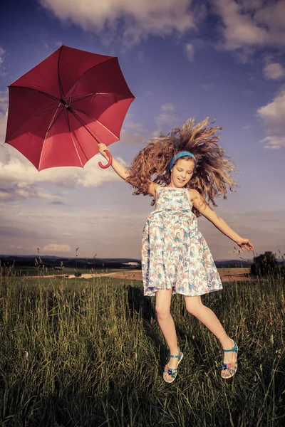 Прыгающая девушка с зонтиком — стоковое фото