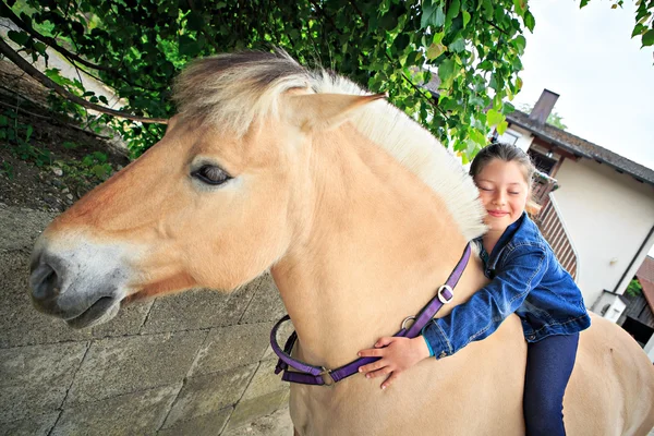 Petite fille étreignant cheval — Photo