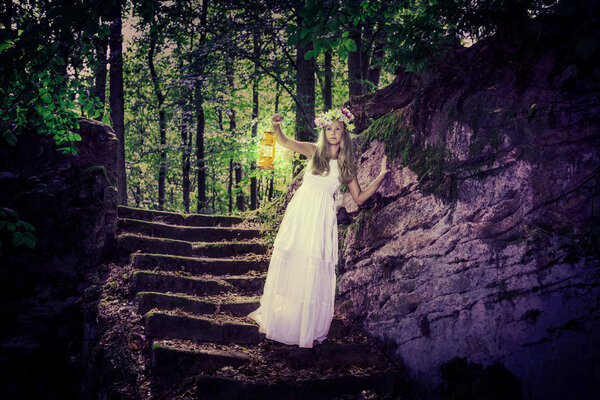 An outdoor portrait of a teenage girls in the dark forest in book cover style