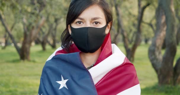 一个戴着保护面具戴着美国国旗的年轻女子的画像 大流行病概念 — 图库视频影像
