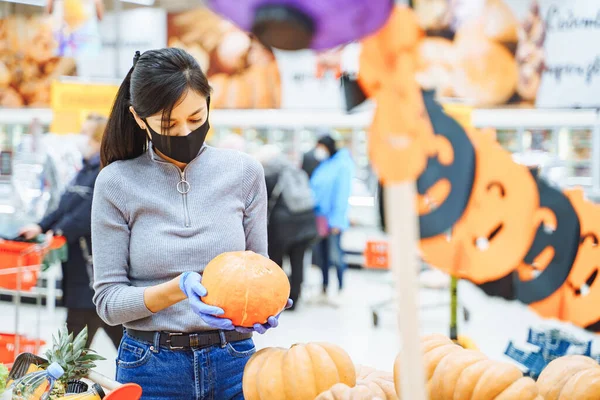 Молодая Женщина Защитной Маске Перчатках Выбирает Тыквы Хэллоуин Супермаркете Реальность — стоковое фото