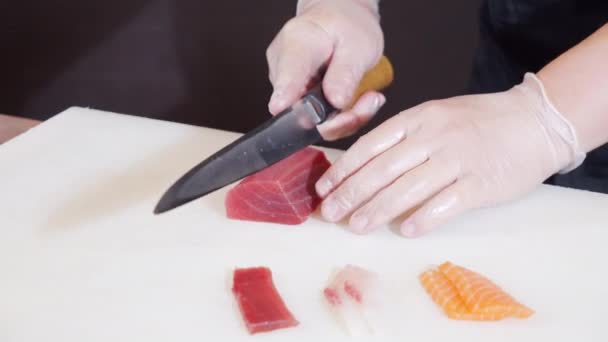 Männliche Kochhände Großaufnahme Handschuhen Schneiden Thunfischfilet Mit Messer Auf Weißem — Stockvideo