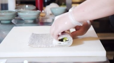 Şeflerin eldiven takmış, yumuşak peynirli suşi, avokado ve havyarlı sandviçlerini pişirirken yakın çekim..