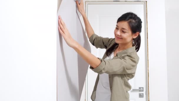 Young Happy Woman Applying Roll Wallpaper Wall Renovation New Housing — Stock Video