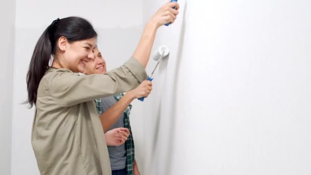 Jong Gelukkig Koppel Schilderen Muur Met Verfrollen Nieuw Huis Diy — Stockvideo