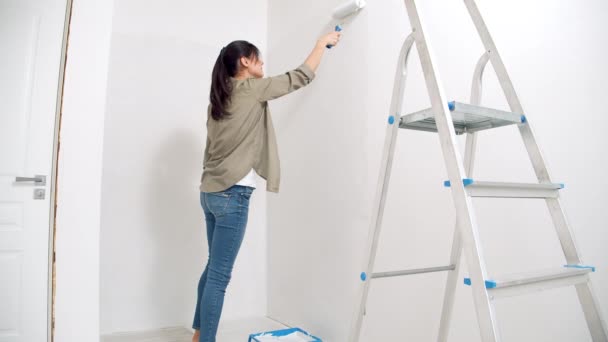 Mujer Joven Pintando Pared Con Rodillo Nuevo Concepto Vivienda Renovación — Vídeo de stock