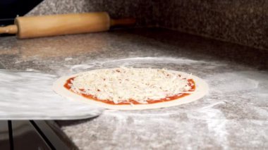 Pizzacının mutfağında lezzetli margarita pizzası yapmak için yakın çekim..