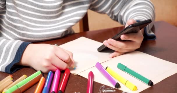 Close Mãos Criança Segurando Smartphone Desenho Com Lápis Colorido Papel — Vídeo de Stock