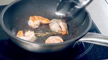 Kızartma tavasında biberiye ile kızartılmış taze iştah açıcı karides yakın plan..