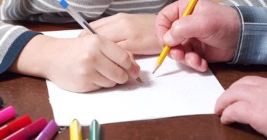 Çocukların ve yaşlı ellerin kağıda tic-tac-toe çizimleri. Ev eğlencesi..