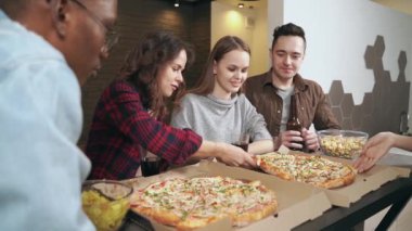 Mutlu genç insanlar, en iyi arkadaşlar güler, birlikte pizza yer, mutfakta bira içerler..