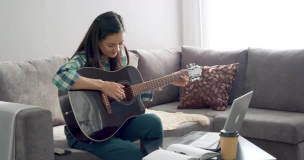 Jovem Tocando Guitarra Acústica Aprendendo Música Remotamente Usando Laptop Enquanto — Vídeo de Stock