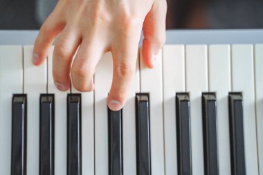 Erkek elin elektrikli piyano çalarkenki yakın çekimi. Geçmişi. Üst görünüm