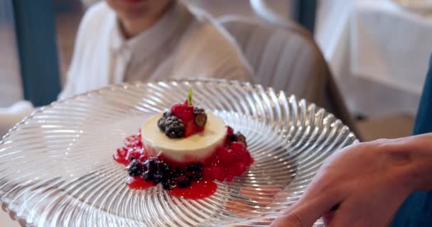 Detailní záběr nejdelikátnějšího dezertu s kousky ovoce a bobulí na talíři. Podávání jídla v restauraci. — Stock video