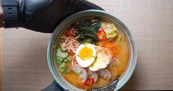 Close-up van heerlijke ramen met kip en groenten. Chef handen in handschoenen serveren een bord soep op de tafel. Kopieerruimte — Stockvideo