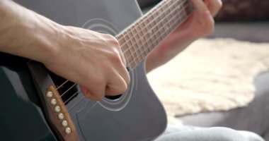 Evde akustik gitar çalan erkek ellerinin yakın çekimi