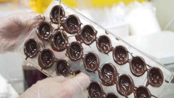 Close-up tiro de um chef mãos em luvas preparando deliciosos doces de chocolate escuro na cozinha. Cozinha de fusão. — Vídeo de Stock