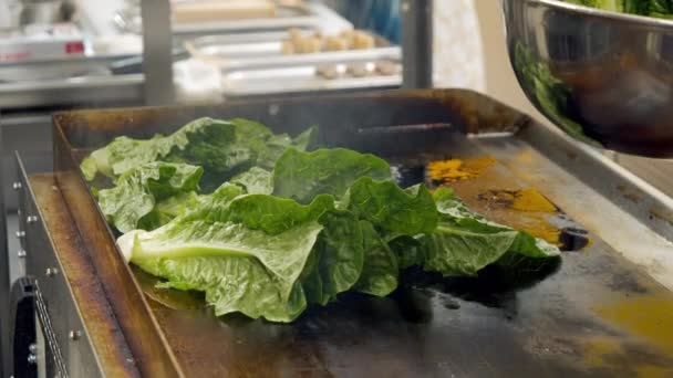 Närbild skott av färsk spenat blad stekt i en professionell stekpanna i köket. Processen att laga hälsosam mat i en restaurang. — Stockvideo