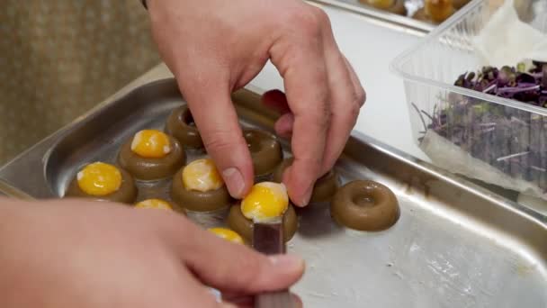 Mutfakta yumurta sarısı ile lezzetli atıştırmalıklar hazırlayan erkek şeflerin yakın çekimi. Moleküler ya da füzyon mutfağı — Stok video