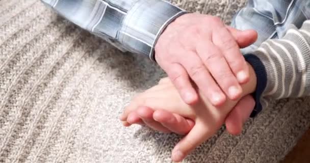Ηλικιωμένα χέρια αγγίζουν και χαϊδεύουν τα παιδιά χέρι. Συνέχεια των γενεών. Κλείστε τα χέρια του εγγονού και του παππού. — Αρχείο Βίντεο