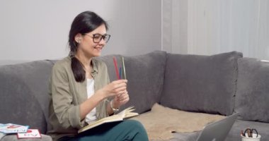 Evde dizüstü bilgisayar kullanarak bir çocuğa veya çocuklara renk öğrenmeyi öğreten genç bir bayan öğretmen. Anaokulu Çevrimiçi Eğitim Konsepti