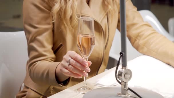 Nierozpoznawalna kobieta pijąca szampana podczas manicure w salonie spa. Koncepcja pielęgnacji ciała — Wideo stockowe