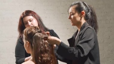 Profesyonel kuaför ve makyaj sanatçısı bir güzellik salonunda genç bir bayan müşteriye makyaj yapıyor. Güzellik ve moda kavramı. Ağır çekimde çekmek.