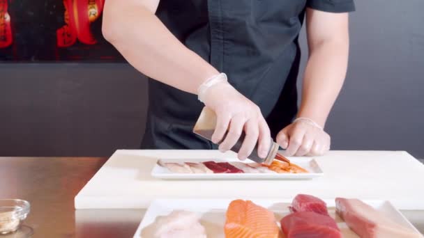 Primo piano delle mani maschili dello chef in guanti che preparano delizioso antipasto di pesce fresco e calamari con salsa al tartufo ed erbe aromatiche su un piatto. — Video Stock