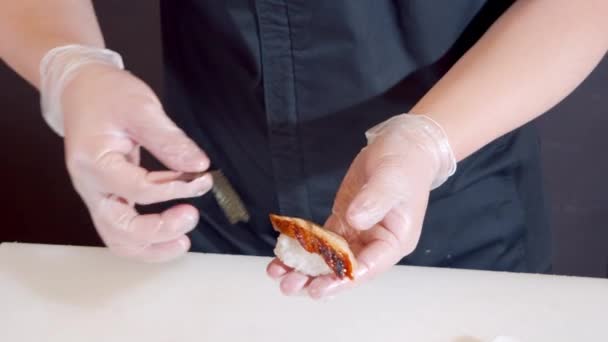 Крупный план мужчины руки повара в перчатках приготовления сашими с тунцом на кухне — стоковое видео