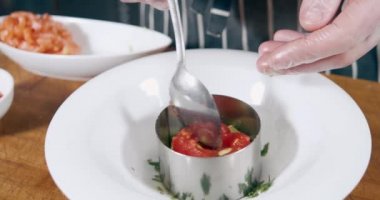 Erkek şefin eldiven giyip, mutfakta avokado, domates ve somon ile lezzetli tartar hazırladığı yakın plan çekimler. Sağlıklı ve organik yiyecekler.
