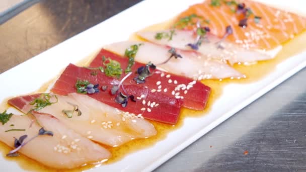 Zbliżenie pyszne przystawki świeżych ryb i kałamarnic z sosem truflowym i ziół na talerzu. — Wideo stockowe