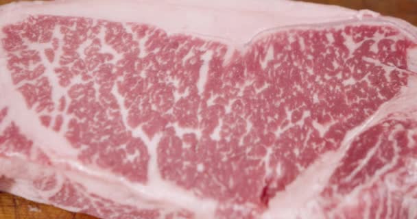 Gros plan de steak de bœuf marbré cru. Caméra en mouvement. Contexte. — Video