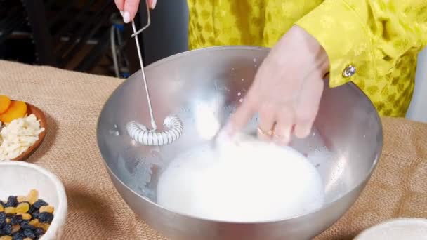 Primer plano de las manos femeninas preparando la masa para sabrosos pasteles con pasas y frutos secos en las cocinas. Concepto de vacaciones de Pascua. — Vídeo de stock