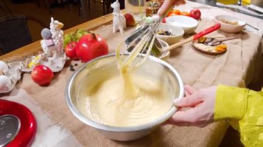 Mutfakta çırpıcıyla lezzetli çörekler için hamur hazırlayan kadınların yakın plan çekimleri.