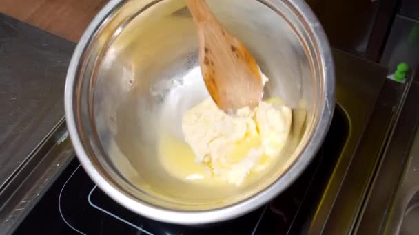 Close-up de mãos femininas derretendo um pedaço de manteiga em uma frigideira quente. — Vídeo de Stock