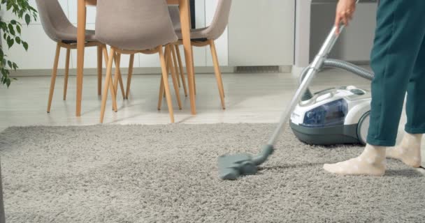 无法辨认的妇女在家里用真空吸尘器清扫地毯上的灰尘和碎片. — 图库视频影像