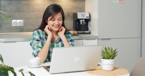 Portrait de femme souriante ayant appel vidéo en ligne sur ordinateur portable à la cuisine. femme heureuse bavarder avec un ami sur un ordinateur portable à la maison. — Video
