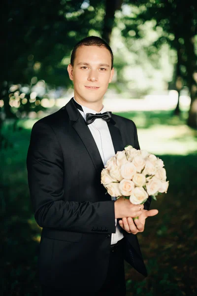 Stilig unga brudgummen poserar utanför i naturen — Stockfoto