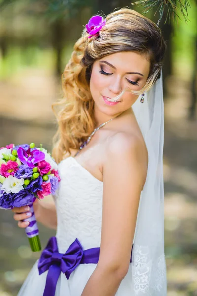 La chica en un vestido de novia con lazo púrpura —  Fotos de Stock