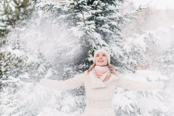 Happy young woman playing with snow