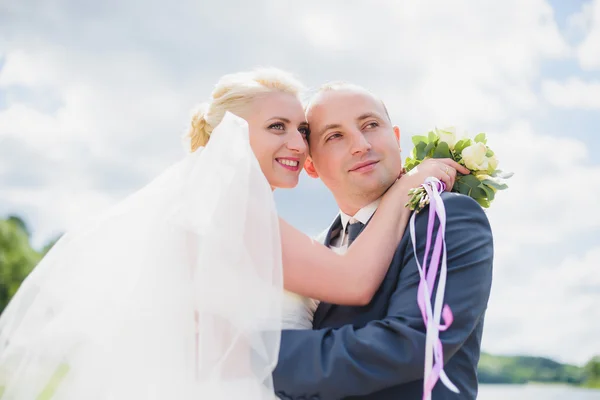 Bride and groom walking on the river — Stock Photo, Image