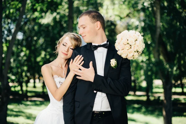 Bruid en bruidegom buitenshuis op een trouwdag in park — Stockfoto