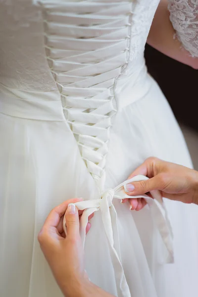 Bruid binden witte trouwjurk — Stockfoto