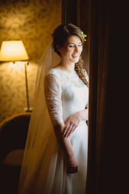 Gelin bir beyaz elbise ayakta yakınındaki penceresi
