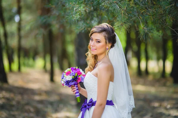 A menina em um vestido de noiva com arco roxo — Fotografia de Stock