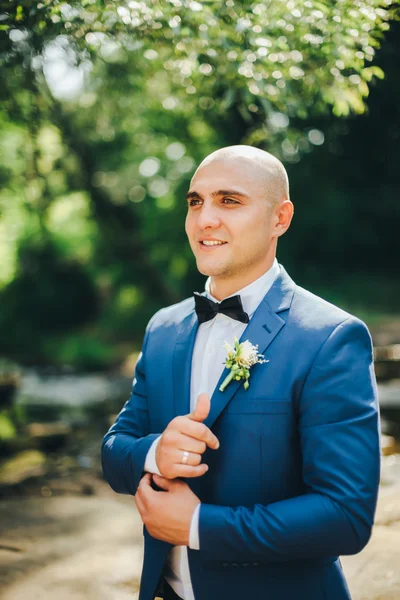 Bräutigam im blauen Anzug knöpft Manschetten — Stockfoto