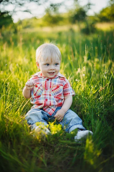 Niño sentado en la hierba — Foto de Stock